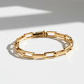 Pulseira Cartier Inspired - semijoia dourada com elos alongados sobre mesa branca