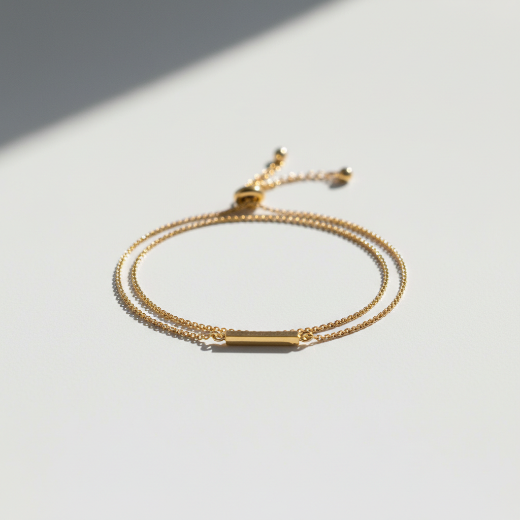 Pulseira Ajustável Minimalista - semijoia dourada fina sobre mesa branca