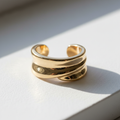 Brinco Ear Cuff Elegance - semijoia dourada minimalista sobre mesa branca